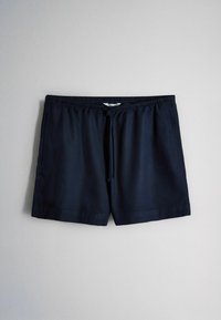 Marineblaue Shorts mit elastischem Bund, Kordelzug, Seitentaschen und geradem Saum vor einem schlichten hellen Hintergrund.