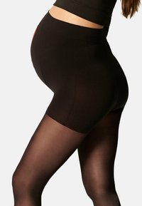 Collant neri a vita alta con una texture morbida ed elastica, di lunghezza fino a metà coscia e con una leggera lucentezza. Cuciture rinforzate sui lati.