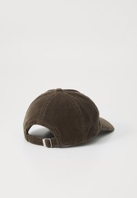 Brown corduroy baseball cap with a curved brim, adjustable back strap, and textured ribbed fabric detailing.