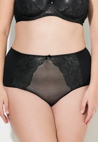 Czarne majtki wysokiej talii z koronkowymi wstawkami i przezroczystym materiałem. Ozdobione małą kokardką na środku. Gładkie wykończenie z elastycznym pasem.