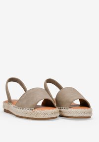 Espadrillas slingback in suede taupe con suola in juta intrecciata. Presentano due ampie aperture e una soletta piatta e flessibile.