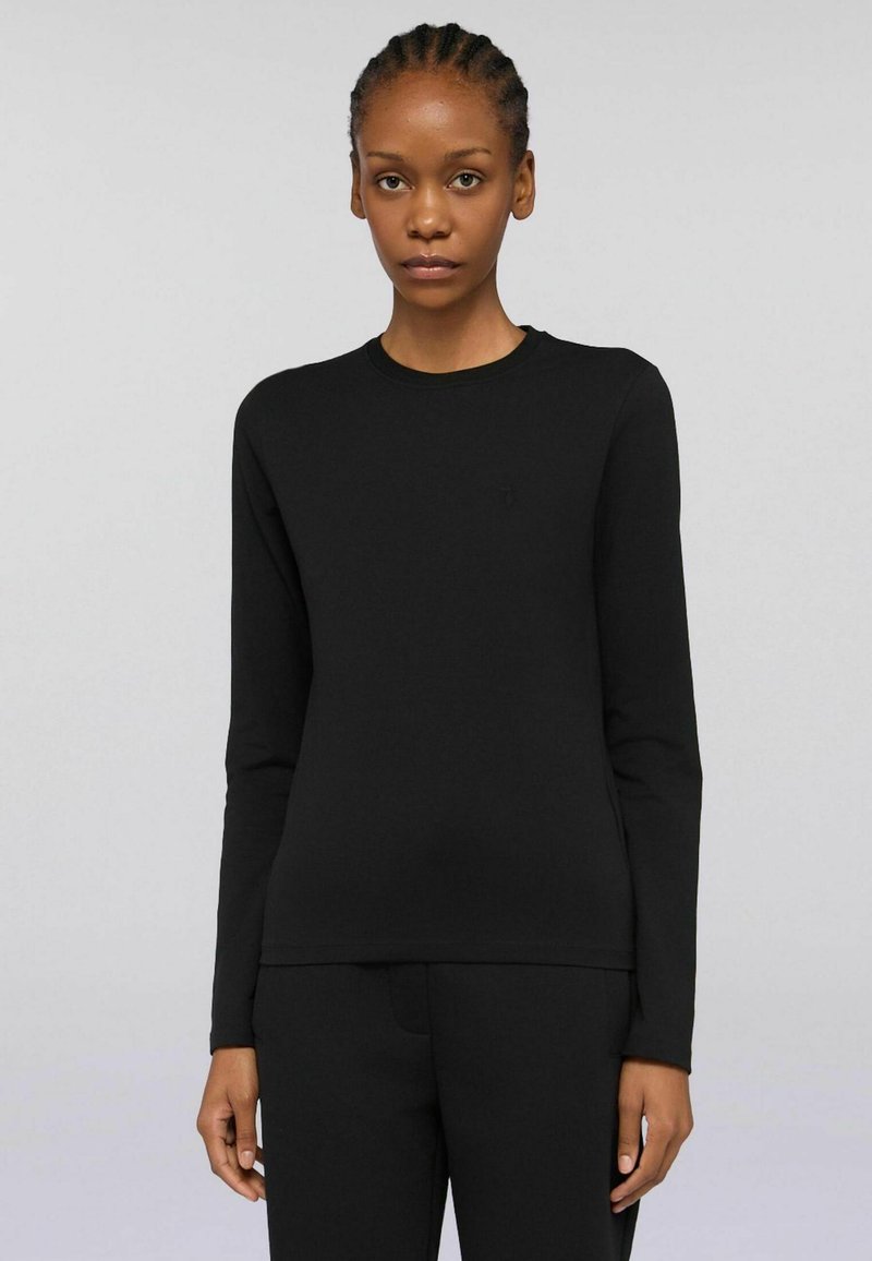 Maglietta nera a maniche lunghe con scollatura a girocollo e silhouette aderente. Realizzata in tessuto liscio con dettagli minimi e un logo sottile.