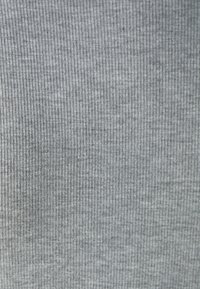 Szürke bordázott textil finom, függőleges vonalakkal, puha tapintással és egyenletes mintázattal. Ruházati és kárpit használatra alkalmas.