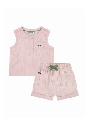Top rose sans manches texturé avec trois boutons et short assorti avec nœud vert et logo Lacoste sur les deux pièces.