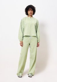 Lichtgroen geruit loungewear set met een losse top met een halve rits en relaxte broek met een verstelbare trekkoordtaille.