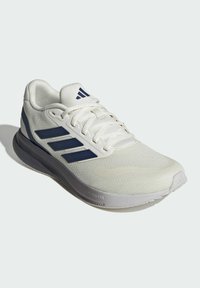 Zapatilla deportiva blanca con acentos azules, parte superior de malla, lengüeta acolchada y suela intermedia Cloudfoam. Forma Curvada y superficie texturizada en la suela exterior.