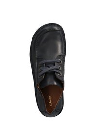 Zapato de cuero negro con punta redondeada, detalles de costura y cordones texturizados. Acabado suave con un interior marrón y un logo.