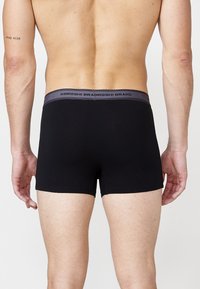 Fekete boxer alsónadrág szürke gumival. A gumi szalagján a "KOROSHI BRADROSHI" márkanevének felirata található fekete színben. Simas texture.