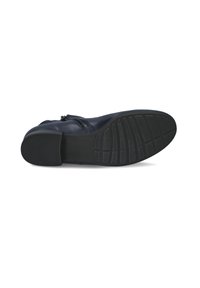 Zapato de cuero negro con suela de goma texturada. Presenta un acabado suave, punta redondeada y un sutil detalle de costura cerca del cierre de cremallera.