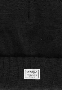 Gorro de punto negro con una etiqueta rectangular blanca que dice "ZIGZAG ACTIVE LIFESTYLE #zigzagkids" en el puño doblado.