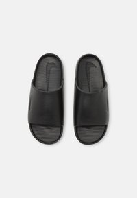 Paire de sandales en caoutchouc noires à enfiler, avec une semelle texturée et une large bride, vues de dessus sur fond blanc.