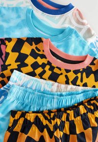 Cztery kolorowe ubrania o różnych wzorach: dwie niebieskie koszulki tie-dye i dwie wzorzyste szorty z czarnymi i pomarańczowymi akcentami.