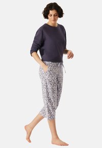 Donker paarse katoenen sweatshirt met lange mouwen, gecombineerd met blauw en witte 3/4-broek met patroon, voorzien van een elastische tailleband en zakken.