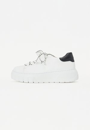 Witte leren sneaker met een chunky zool, zwarte hielaccent en zwart-wit gestreepte veters. Beschikt over een gladde textuur en stikseldetails.