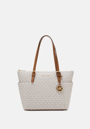 Beżowa torba typu tote Michael Kors z wzorem logo MK na całej powierzchni, brązowymi skórzanymi paskami oraz okrągłą złotą zawieszką MK po boku.