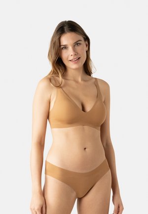 Ensemble de sous-vêtements beige comprenant un bralette à côtes doux avec un décolleté en V et des bretelles ajustables, assorti à des culottes taille basse.
