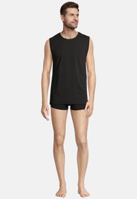 Black sleeveless cotton top and fitted black shorts. The design is simple, with smooth texture and no patterns or embellishments.