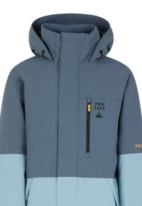 Plava jakna s kapuljačom, koja ima svijetloplavi donji dio, crni zip, i prednji džep s zlatnom polugom. Logo je na gornjoj lijevoj strani.