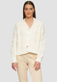 Cremfarbener, gestrickter Cardigan mit V-Ausschnitt, geripptem Saum und langen Ärmeln. Verfügt über ein strukturiertes Muster mit offener Webart für Atmungsaktivität.