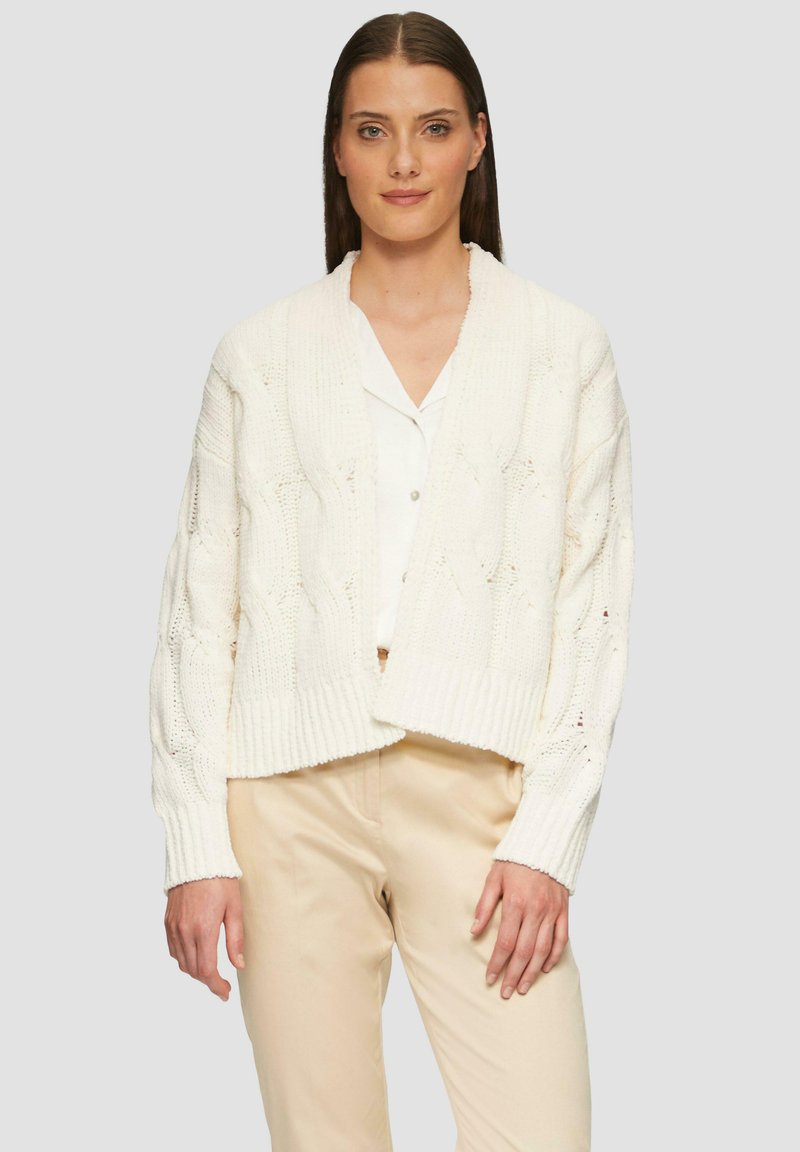 Cremfarbener, gestrickter Cardigan mit V-Ausschnitt, geripptem Saum und langen Ärmeln. Verfügt über ein strukturiertes Muster mit offener Webart für Atmungsaktivität.