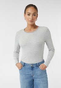 Grau-weiß gestreiftes Langarmshirt mit Rundhalsausschnitt, kombiniert mit hellblauen hoch taillierten Jeans. Weicher Stoff.