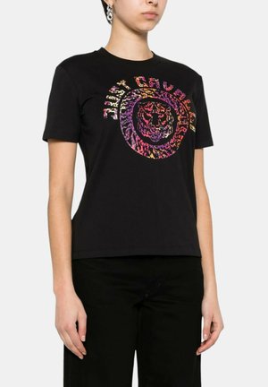 T-shirt nera in cotone con una grafica di tigre colorata e un design testuale circolare in tonalità vivaci, maniche corte e stile classico.