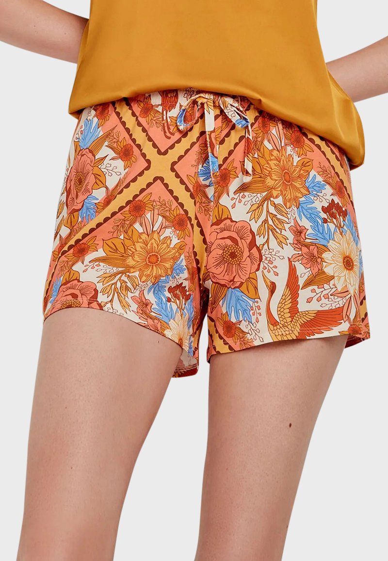 Los shorts de estampado floral presentan una paleta de colores en naranja, azul y crema, con una cintura ajustable y un diseño estampado que incorpora flores y un pájaro.