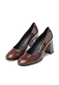 Scarpe con tacco alto in pelle di serpente marrone con finiture lucide, punta rotonda e robusto tacco a blocco, che mostrano una superficie in pelle testurizzata.