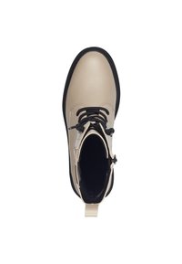 Bottines en cuir beige avec des lacets noirs, semelle en caoutchouc, boucle avant et texture lisse. L'intérieur présente une doublure sombre.