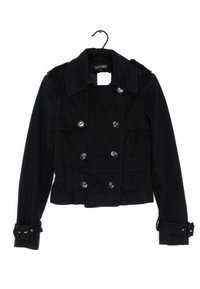 Svart, kort jacka med dubbelknäppt design, stor krage, silverknappar och justerbara ärmar. Tillverkad av ett texturerat tyg.