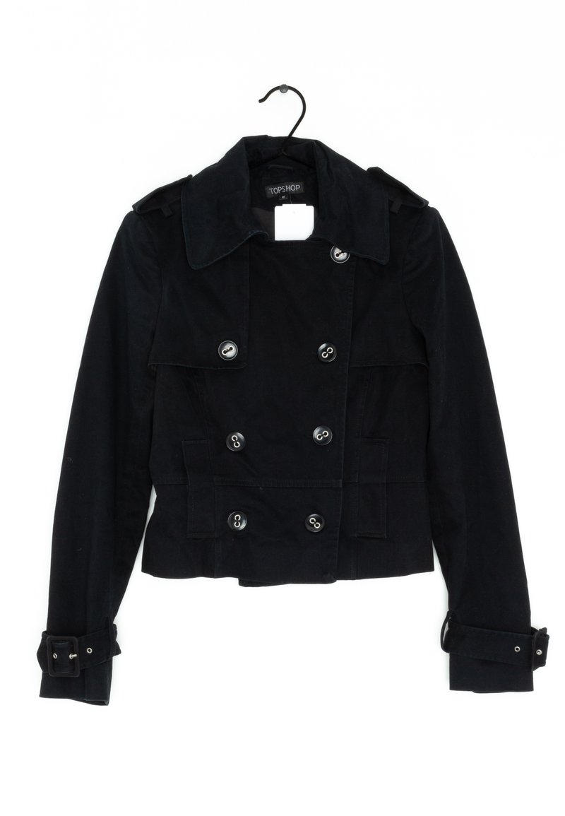 Svart, kort jacka med dubbelknäppt design, stor krage, silverknappar och justerbara ärmar. Tillverkad av ett texturerat tyg.