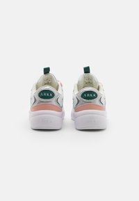 Adidași albi cu accente de argint și roz deschis, având o eticheta cu logo verde pe călcâi și o talpă texturată albă.