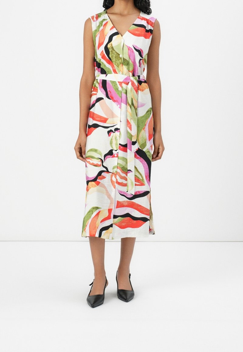 Robe midi sans manches avec imprimé abstrait coloré, col en V, boutonnage devant et ceinture en tissu assorti, portée avec des escarpins noirs à bouts pointus.