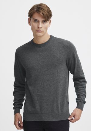 Dark gray sweater made from a soft fabric, featuring a crew neckline, long sleeves, and ribbed cuffs and hem. Minimal branding on side.