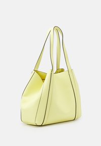 Gele leren tas met een nonchalant ontwerp, contrasterende zwarte randen en twee lange handvaten. Soepele textuur met een ruime binnenkant.