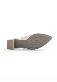 Scarpa in suede beige con tacco quadrato basso, dotata di una suola in gomma testurizzata con un motivo a onde. Design a taglio semplice, senza ulteriori accenti.