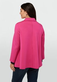 Rosa, skräddarsydd kavaj med utsvängd design och långa ärmar. Har en fyrstegskrage och detalj på bakstycket. Tillverkad av ett smidigt tyg.