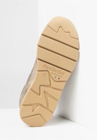 Gummisula i tanfärgat gummi med strukturerat mönster; präglad med "NeroGiardini" och italienska flaggan. Profilen framhäver en lättviktig design.