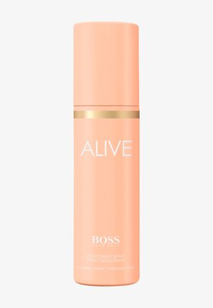 Perzikkleurige BOSS Hugo Boss Alive deodorant spraysprayfles met gouden band en witte tekst op een witte achtergrond.