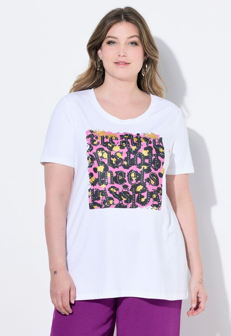 Hvid bomulds T-shirt med en farverig grafisk tryk og sort tekst på en lyserød baggrund. Korte ærmer og en rund halsudskæring.