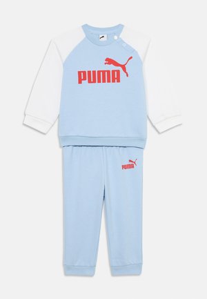 Fato de treino azul claro composto por uma sweatshirt de gola redonda com mangas brancas e logótipo vermelho "PUMA", combinado com calças azuis correspondentes e logótipo.
