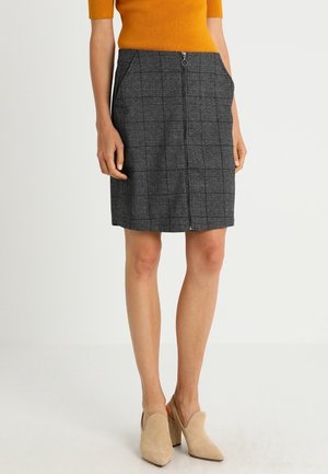 Grijze geruite rok met een rechte snit, voorzien van zijzakken en een ritssluiting aan de voorkant, gecombineerd met beige hakken en een oranje top.