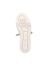 Weiße Sneaker-Sohle mit strukturiertem Grip-Muster und Rillen. Enthält ein Logo-Detail. Das Material wirkt gummiartig und flexibel.