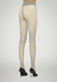 Beige strømpebukser med en glat tekstur, høj talje og rygsyning. Båret med sorte høje hæle, der fremhæver en ben-huggende design.