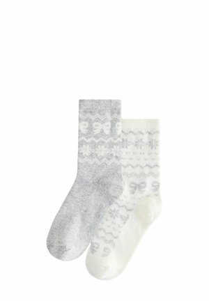 Graue und weiße gemusterte Socken aus weichem Material. Eine Socke ist grau mit Schleifen, die andere cremefarben mit Schneeflocken und Zickzackmustern.