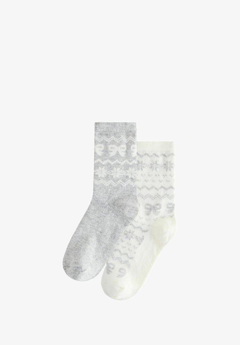 Hall ja valged sokid pehmest materjalist. Üks sokk on hall, millel on paelad, teine on kreemjas, millel on lumehelves ja sakilised mustrid.