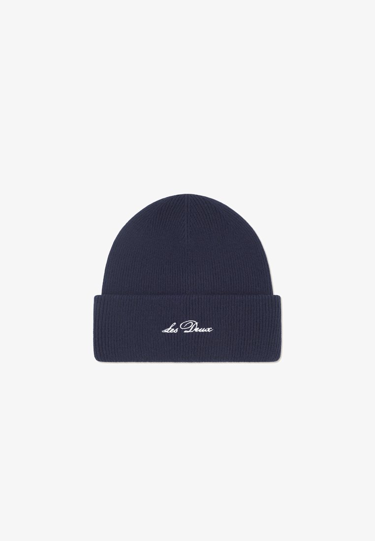 Navy knit beanie with ribbed texture and a folded cuff featuring white embroidered text “Les Deux.” Simple, close-fitting design.