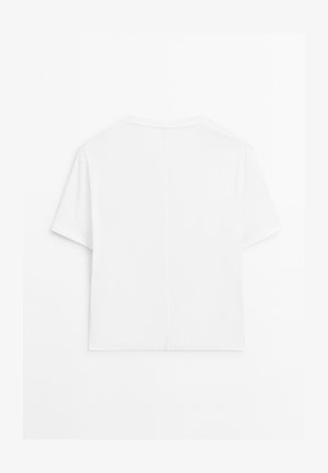 Prosta, biała, krótko rękawowa koszulka z okrągłym dekoltem, z centralnym szwem biegnącym pionowo wzdłuż pleców, prezentowana na białym tle.