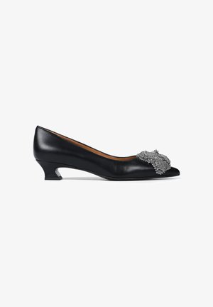 Czarne skórzane czółenka z ostrym noskiem i niskim klinem. Udekorowane srebrną metaliczną siateczką na nosku. Gładka tekstura.