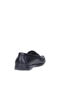 Zapato negro de piel tipo slip-on con textura suave, forma redondeada y suela de goma baja y texturizada. Detalle de costura sutil en los laterales.